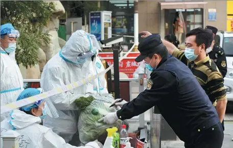  ?? WU XIAOYU / FOR CHINA DAILY ?? Volunteers deliver food and other daily necessitie­s on Monday to residents of a community in Xingqing district, Yinchuan, Ningxia Hui autonomous region. The community was locked down due to a close contact with a confirmed COVID-19 patient.