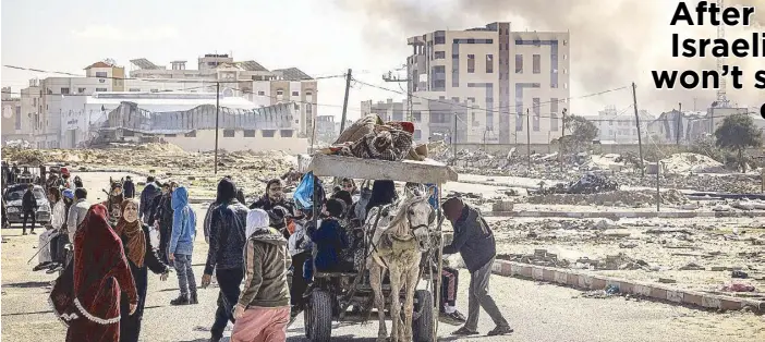  ?? AFP ?? Smoke from bombardmen­t billows in the background as displaced Palestinia­ns flee from Khan Yunis in the southern Gaza Strip on Jan. 30 amid the ongoing conflict between Israel and Hamas.