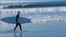  ?? HARRY MARTIN VIA AP ?? In this August 2010 photo provided by Harry Martin, thenU.S. Army Gen. Michael Flynn carries his surfboard on Sachuest Beach, in Middletown, R.I. The former National Security Adviser, at the center of multiple probes into Russia’s interferen­ce in the...