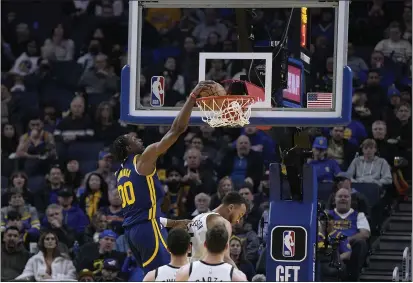  ?? THEARON W. HENDERSON – GETTY IMAGES ?? The Warriors' Jonathan Kuminga dunks over Kyle Anderson for two of his 13points in Sunday's victory over the Timberwolv­es at Chase Center.