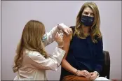  ?? JESSICA HILL — THE ASSOCIATED PRESS ?? Kindergart­en school teacher Christina Kibby receives the Johnson & Johnson COVID-19vaccine by pharmacist Madeline Acquilano, left, at Hartford Hospital in Hartford, Conn., on Wednesday.