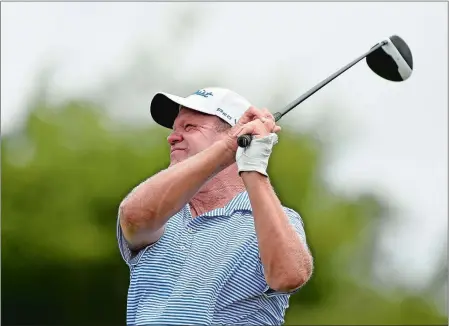  ?? SEAN D. ELLIOT/THE DAY ?? John Elliott watches his tee shot on the 14th hole during the opening round of the Connecticu­t Senior Open golf tournament on Monday at Shennecoss­ett Golf Course in Groton. The ex-NFA star shot a 4-under 67 and has a share of the lead heading into...