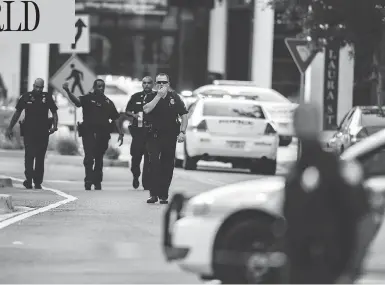  ?? LAURA HEALD / THE ASSOCIATED PRESS ?? Police respond to a shooting at Jacksonvil­le Landing mall in Jacksonvil­le, Fla., on Sunday. Police said three people, including the suspect, were killed and another 11 were injured during the shooting at a video game tournament.