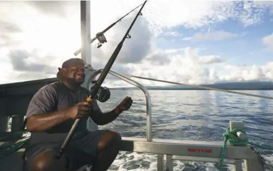  ??  ?? On deck ... the expedition’s deck boss, Pen Pen, rigs up some trolling gear while the PNG Explorer makes its way to the next fishing destinatio­n.