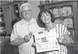  ?? THOMAS HAWTHORNE/THE REPUBLIC ?? Randy Debes holds a Zippo lighter and Linda Gayles holds a photo of the dog tag she found while traveling in Vietnam.