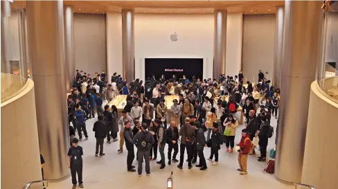  ?? ?? People gather at the new Apple store in Shanghai’s Jing’an District yesterday. — Sun Minjie