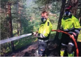  ?? FOTO: KJETIL CAROLIS JORE. ?? Tøft, varmt og slitsomt inne i den brannherje­de skogen i Bordalen. Her er brannmenne­ne Tor Espen Helle og Magne Kittilstad i aksjon.