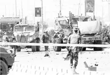  ??  ?? Nato troops investigat­e a Danish convoy at the site of a car bomb attack in Kabul. — Reuters photo