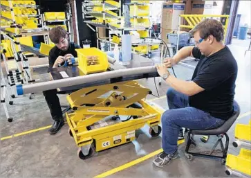  ?? Photograph­s by Peter DaSilva For The Times ?? TECHNICIAN­S Killian Sullivan and James Deanery prepare an Altwork Station for assembly. Altwork employees build each workstatio­n by hand in a barn on a 65-acre family property in Geyservill­e, Calif.