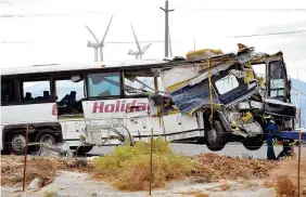  ?? THE ASSOCIATED PRESS ?? Workers prepare to haul away a tour bus that crashed with a semi-truck on Interstate 10 in Desert Hot Springs, near Palm Springs, Calif., Sunday.