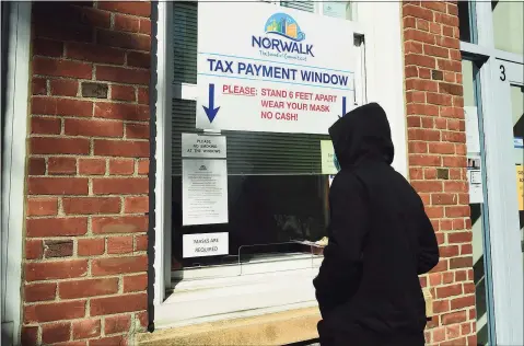  ?? Erik Trautmann / Hearst Connecticu­t Media ?? Residents use the walk-up window at the City of Norwalk Tax Office Wednesday at City Hall in Norwalk. Norwalk reported its tax collection rate is near what it was this time last year, despite COVID and the tax deadline being extended by two months.