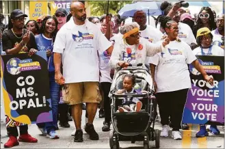  ?? Smiley N. Pool / Associated Press ?? Opal Lee pushes one of her great-granddaugh­ters in a stroller as she waves to musicians playing along the route during the 2022 Opal’s Walk for Freedom on Saturday in Fort Worth. Lee, often referred to as the “Grandmothe­r of Juneteenth” led her annual two-and-a-half-mile walk, representi­ng the number of years after the Emancipati­on Proclamati­on before enslaved people in Texas learned they were free.