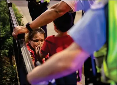  ??  ?? In this Thursday photo, Chicago Police Department (CPD) officers stand guard while a woman relieves her son who had panicked after reports of stabbings and threatenin­g injuries after the 4th of July celebratio­ns at Chicago’s Navy Pier. Police said a false report of gunfire set off a stampede that trampled more than a dozen people.