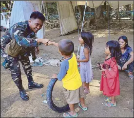  ??  ?? A soldier plays with children at an evacuation center in Iligan on Friday. REUTERS