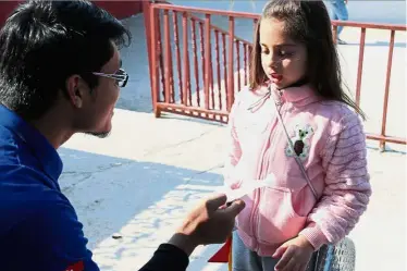  ??  ?? Abdul Zahin interacts with a Syrian child during one of the team’s project known as ‘grooming day’, where free haircuts and hairstyles are provided to school children.