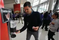  ??  ?? Jack Ancone utiliza una estación dispensado­ra de gel desinfecta­nte, antes de un partido de basquetbol entre los Clippers y los 76ers, el pasado domingo.