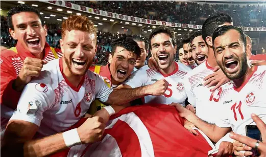  ?? — AFP ?? Drawing
cheers: Tunisia players celebratin­g with the country’s after qualifying for the 2018 World Cup in Russia. Tunisia were held to a 0- 0 draw by Libya in the qualifier in Tunis on Saturday.