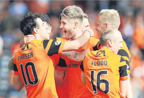  ??  ?? Scott Fraser is congratula­ted by his team-mates after he scores Dundee United’s second goal at Tannadice yesterday.