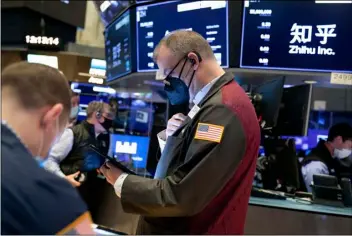  ?? Nicole Pereira/New York Stock Exchange via AP ?? In this photo provided by the New York Stock Exchange, William Lawrence, center, works with fellow traders on the floor, on Friday.