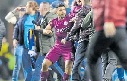  ??  ?? Furia. Del Kun Agüero con los hinchas del Wigan que entraron a celebrar el triunfo sobre el Manchester City.