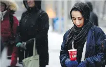  ?? RYAN MCLEOD ?? Fatima Alrmah holds a candle as she joined hundreds of others who came together at City Hall on Friday.