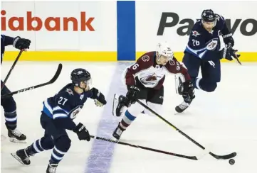  ?? (USA TODAY Sports) ?? Colorado Avalanche forward Mikko Rantanen (centre) skates with the puck between Winnipeg Jets forward Nikolaj Ehlers (left) and Winnipeg Jets forward Blake Wheeler during the NHL game on Friday.
