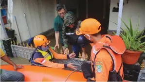  ?? IMAM HUSEIN/JAWA POS ?? CEGAH TERTULAR: Petugas BPPD mengevakua­si warga di Perum Jatibening Permai, Bekasi, Jawa Barat, Jumat (19/2). Untuk mengevakua­si warga yang positif Covid-19, petugas wajib memakai APD.