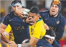  ?? MANHANDLED: Israel Folau is wrapped up by Argentina. ??