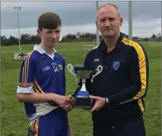  ??  ?? Hugh Kenny presents the first year boys 9-a-side trophy to Colaiste Bhride captain Sean Hughes.