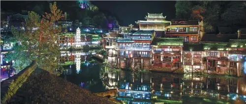  ?? PHOTOS BY YUAN QINGPAN / CHINA DAILY ?? A night view of Fenghuang, a tourist hot spot in Hunan province that is dominated by the culture of the Miao ethnic group.