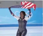  ?? SUE OGROCKI ASSOCIATED PRESS ?? Erin Jackson of the United States hoists an American flag after winning the gold medal in the speedskati­ng women’s 500-meter race Saturday at the Winter Olympics in Beijing.