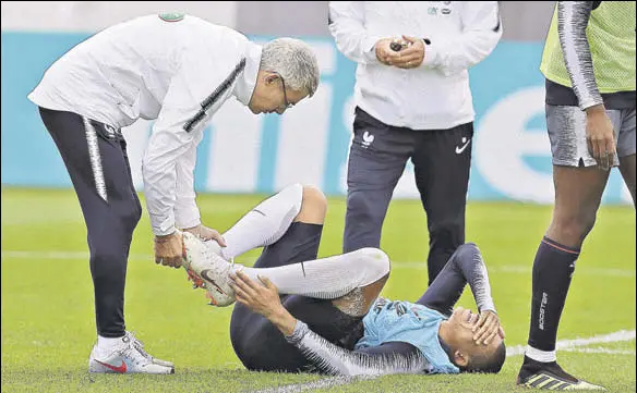  ?? AP ?? France's Kylian Mbappe injured his ankle after a tackle from Adil Rami. The 19yearold forward limped off the training session raising doubts over his World Cup availabili­ty.