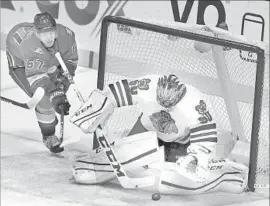  ?? Reed Saxon Associated Press ?? CHICAGO GOALIE Corey Crawford stops a shot as the Ducks’ Rickard Rakell (67) moves in for a potential rebound during the first period at Honda Center.