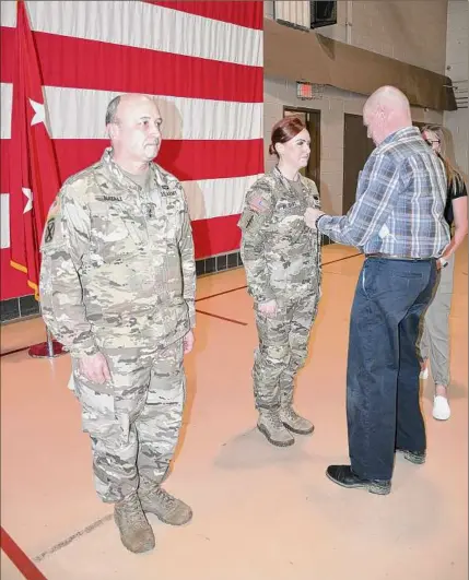  ?? Maj. Jean Kratzer / New York Army National Guard ?? Retired Army Master Sgt. John Leavitt pins master sergeant rank insignia on his daughter Brooke Albert during a ceremony held at the state Division of Military and Naval Affairs Headquarte­rs in Latham.