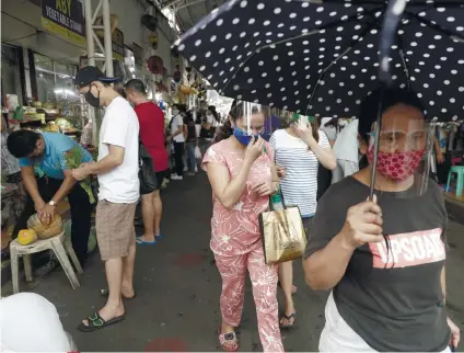  ?? / AP FOTO ?? RECESSION. People wearing face masks buy food at a public market in preparatio­n for stricter lockdown measures in Quezon City, Philippine­s on Monday, Aug. 3, 2020. The country’s gross domestic product growth rate has plunged by 16.5 percent in the second quarter this year.