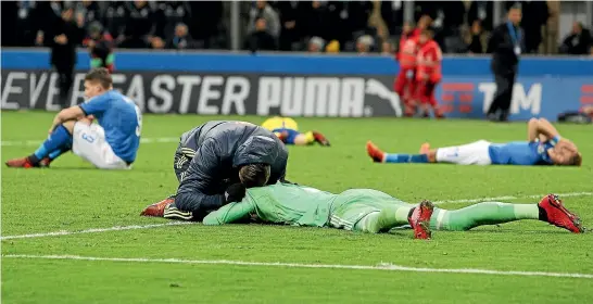  ?? PHOTO: GETTY IMAGES ?? Italian players including star goalkeeper Gianluigi Buffon, front, are inconsolab­le after their team’s failure to qualify for the World Cup finals following their 0-0 draw with Sweden in Milan yesterday.