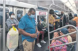  ?? DAVID DEE DELGADO GETTY IMAGES/TRIBUNE NEWS SERVICE ?? People ride the New York subway following the coronaviru­s lockdown. In New York, infection rates have been lower in subway-rich Manhattan than in transit-poor boroughs, like Staten Island.