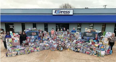  ?? (Submitted photo) ?? Express Employment Profession­als staffers pose for a photo with the results of a previous Spreading Joy, Gifting Hope Toy Drive. This year, Express is hosting their seventh annual toy drive for the holidays. New, unwrapped toys and monetary donations can be dropped off at the Express office during regular work hours until Friday, Dec. 9.