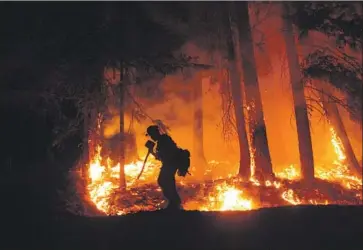  ?? Mike McMillan U. S. Forest Ser vi ce. ?? A MEMBER of the Lassen Hotshot crew battling the August Complex blaze shields his face from the heat. California’s largest wildfire is approachin­g a pot- growing enclave where many have refused to evacuate.