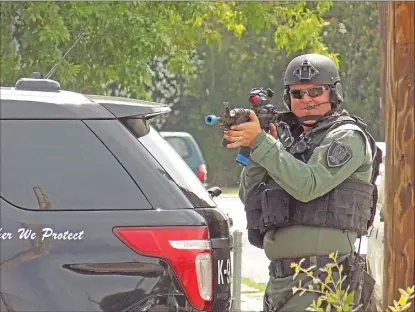  ??  ?? Officer Kenny Sowles aims his simunition gun, which shoots paint bullets, as part of a SWAT training exercise on Wednesday.