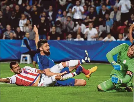  ?? AFP PIC ?? France’s Olivier Giroud (centre) scores his third goal past Paraguay's goalkeeper Antony Silva (right) in their friendly at the Roazhon Park Stadium in Rennes on Friday.