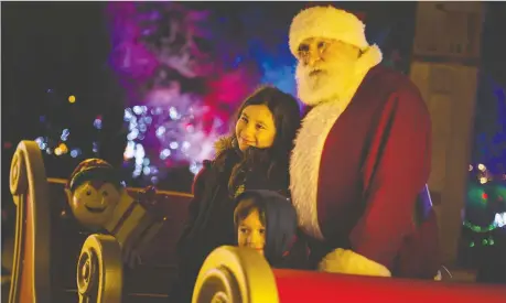  ?? PHOTOS: DAX MELMER ?? Avery and James Sotto pose for a photo with Santa on Friday night during the opening of the third annual Bright Lights Windsor display at Jackson Park. For a video of the celebratio­n, go to windsorsta­r.com.