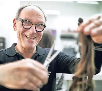  ?? RP-FOTO: STEPHAN KÖHLEN ?? Friseur Winfried Taprogge mit einem gespendete­n Zopf. Aus den abgegebene­n Haaren werden Perücken für Kranke gemacht.