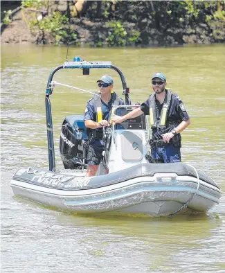  ?? GRIM JOB: Police search Ross River near Oonoonba yesterday. Picture: ALIX SWEENEY ??