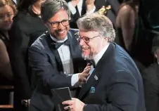  ?? — Reuters ?? Gael Garcia Bernal (left) congratula­tes DelToroast­he latter goes to accept the Oscar for Best Director for The Shape Of Water. Del Toro’s film also received the Best Picture Oscar.