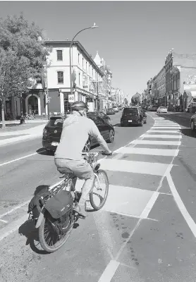  ?? DARREN STONE, TIMES COLONIST ?? A cyclist pedals along new bike lane on lower Johnson Street. A letter-writer agrees with Victoria Mayor Lisa Helps that the green paint marking the lanes is a North American standard for cycling infrastruc­ture.