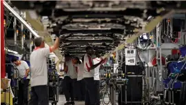  ?? (Albert Gea/Reuters) ?? WORKERS ASSEMBLE vehicles on the production line of the SEAT car factory in Martorell, near Barcelona.