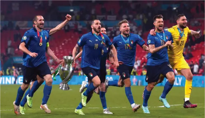  ?? FOTO: NTB ?? Italias kaptein Giorgio Chiellini (t.v.) jubler sammen med sine lagkamerat­er etter seieren over England i Em-finalen på Wembley søndag 11. juli.