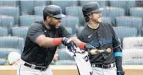  ?? SARAH STIER/GETTY ?? The Marlins’ Jesus Aguilar, left, and Brian Anderson dry off their equipment Sunday in New York.