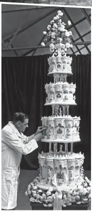  ??  ?? Tiers of joy: In Edinburgh, the chief confection­er at McVitie & Price prepares the 9ft-tall cake